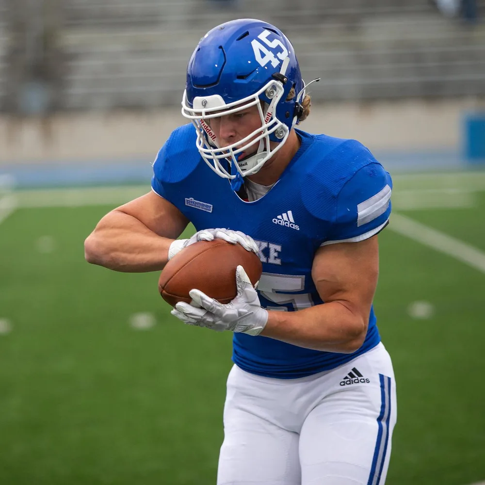 Noah securing a catch in the blue Drake uniform