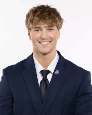 Noah in a navy suit and tie