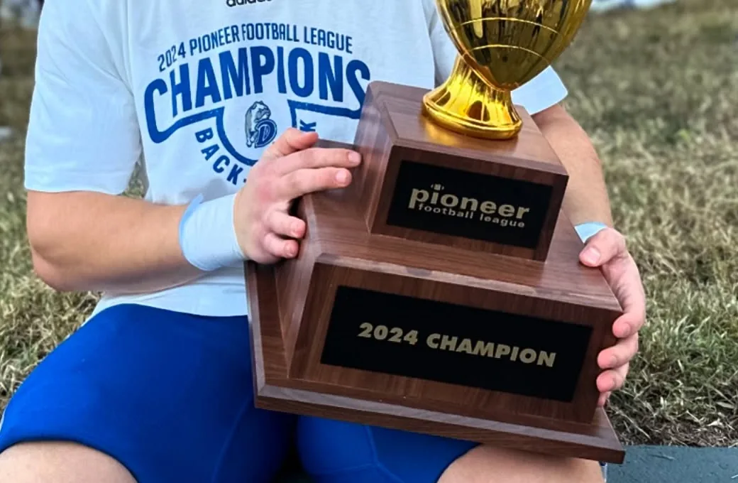 Noah holding the 2024 Pioneer Football League championship trophy
