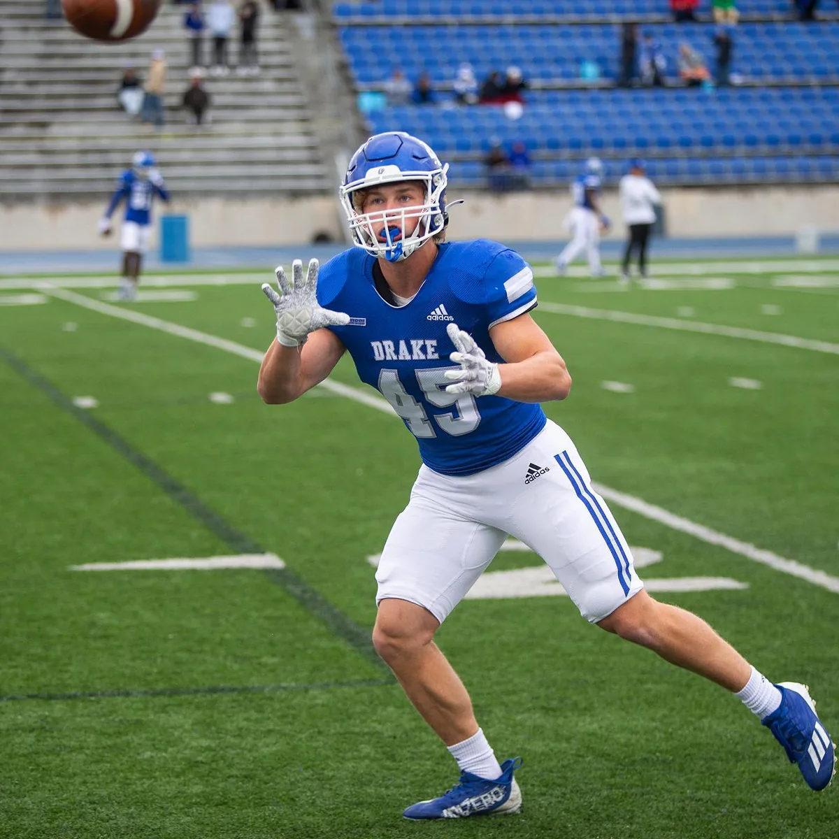 Noah reaching for a pass during warmups at Drake Stadium